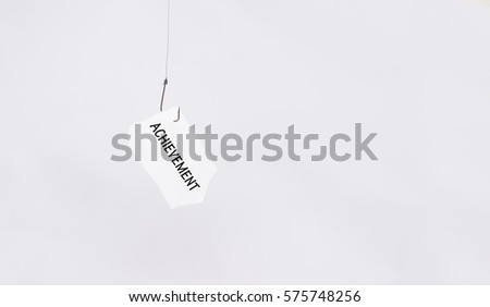 Achievement word on hanging paper using fishing hook