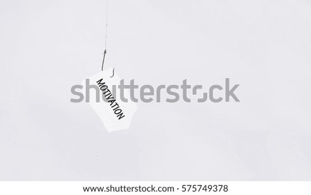 motivation word on hanging paper using fishing hook