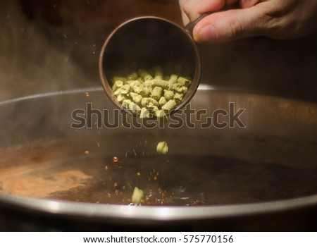 Hop addition into a beer Royalty-Free Stock Photo #575770156