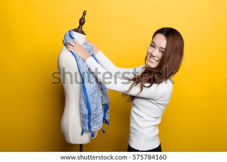 Chinese female designers in front of a yellow background, show themselves