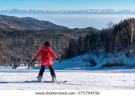 Girl snowboarding on the mountain slope