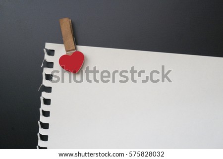 Note paper clip heart on black background