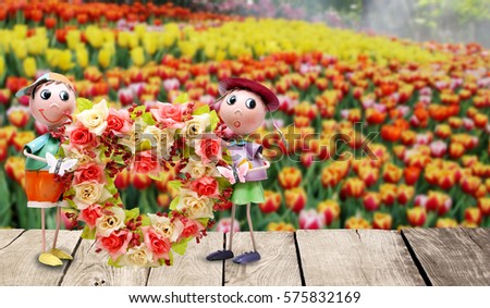 Doll male - female hearts and flowers on a wooden background flowers.