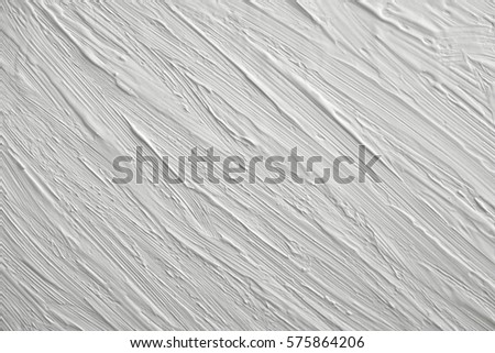 Texture of white paint on a gray background. Volume relief retro.