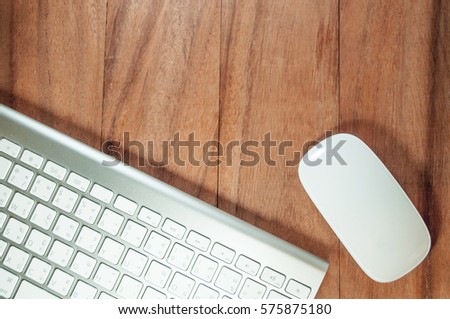 Picture of a silver keyboard and mouse on wood table