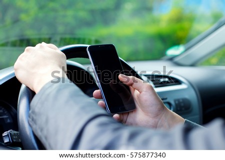 Close up picture of a man using his phone when driving