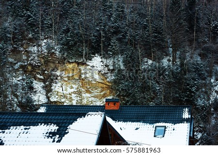 A snowy winter scene of a small house in the heart of Yaremche