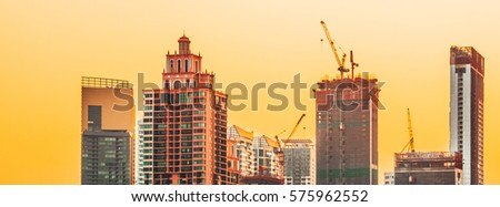Business district cityscape from park in Morning Bangkok Thailand,Construction Site with silhouette sunset