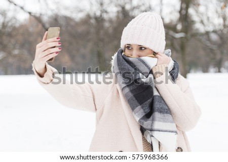 Beautiful blonde woman taking a selfie in winter holidays on the snow