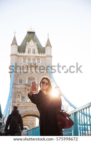 Young fashion woman taking selfie in Tower Bridge