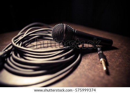 Close up shot of a microphone and some cables.
