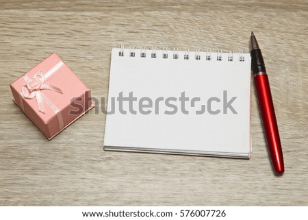 Gift and empty Notebook  on table