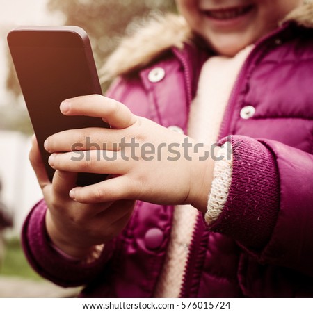 Little girl looking something fun on the phone.