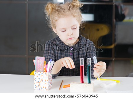 a Caucasian child spends  chemical experiences in class room