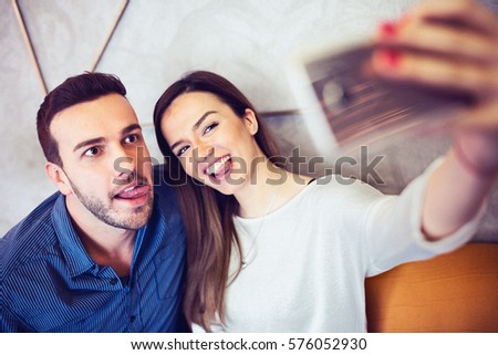 Happy young couple taking selfie by mobile phone. Love and fun concept. Toned photo added grain
