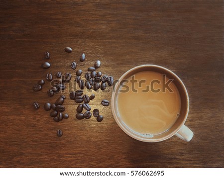 Coffee cup and beans on a table.