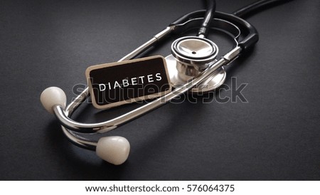 Wooden tag written with DIABETES and stethoscope on black background. Medical and Healthcare Concept

