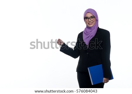 A pretty muslim businesswoman wearing hijab, suit and spectacle pointing her finger at an empty space beside her, isolated on white background