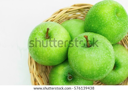 Fresh green apples in a wicker basket. isolated on white background.