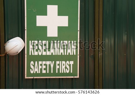 Safety helmet on work place with the sign of 'SAFETY FIRST'. - Words 'KESELAMATAN' is Malay language which mean 'SAFETY' in English.