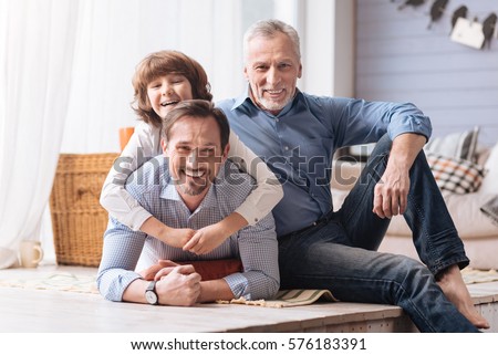 Delighted cute boy hugging his father Royalty-Free Stock Photo #576183391
