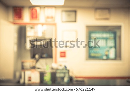 Blurred image of an empty office counter service. Abstract background cashier/checkout with monitor in an small modern automotive oil change shops in America. Vintage tone.