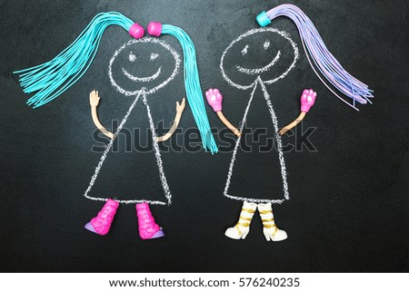 Two painted doll with pigtails on a black background.