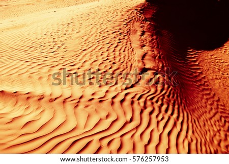 Red-yellow bloody desert texture and background. Natural patterns on the sand