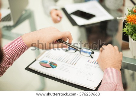 Businessman holding a pen working with the chart, lie near points
