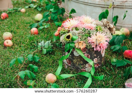 wedding decorations, flowers in a basket and apples on the grass