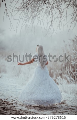 White fairytale princess in frozen world. Vintage wedding dress. Winter fantasy.