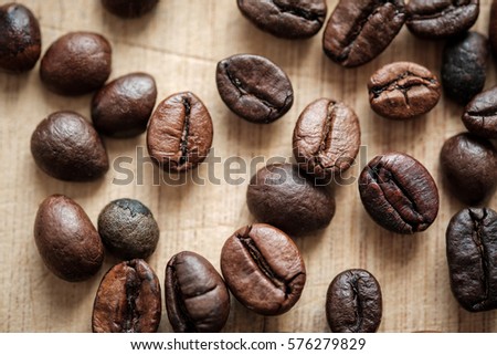 Detail view of coffee beans on wooden background. Macro shoot.