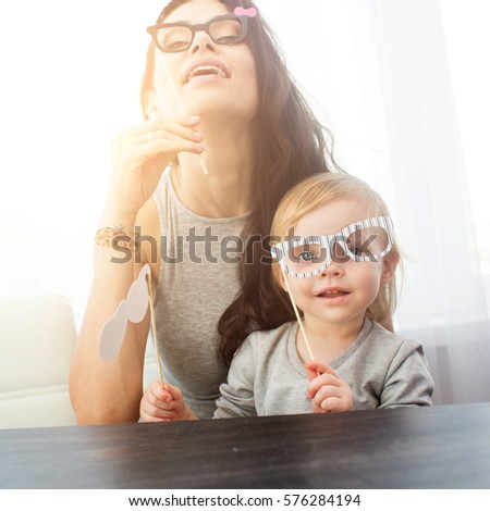 Mother and her daughter with a paper accessories.