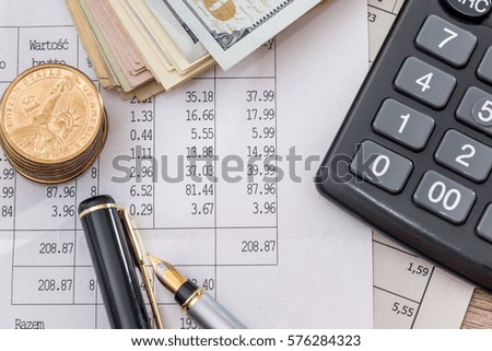 Dollar bills with business documents, pen  and calculator as background.