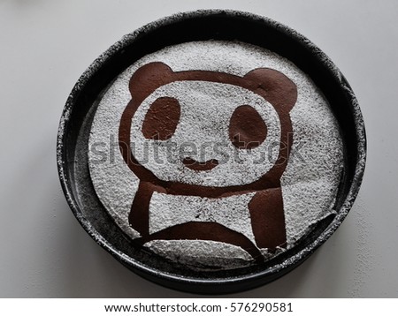 Panda made with sugar on a chocolate brownie cake in a round form