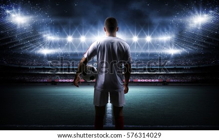 Football player with ball on field of stadium