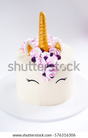 Unicorn layered cake decorated with meringues.
