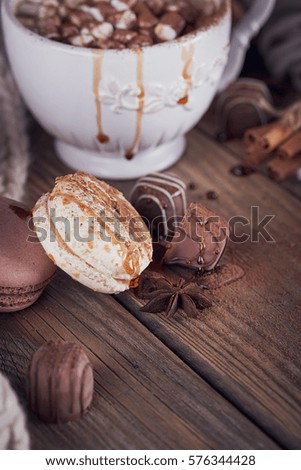 Christmas or New Year composition with hot chocolate or cocoa and marshmallows, decorated with sweets, spices and knitted scarf. Winter holidays background.