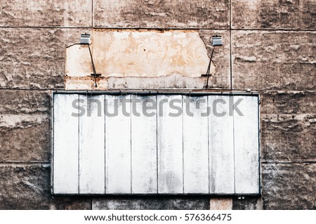 Concrete rundown wall with empty big billboard space lighted where you can add your message.