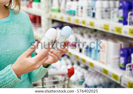 Woman in shop chooses deodorant closeup Royalty-Free Stock Photo #576402025