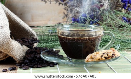 Coffee and cookies on a wood table with dark roasting coffee beans