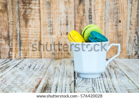 Colorful macarons on vintage pastel background. Macaron or Macaroon is sweet meringue-based confection.
