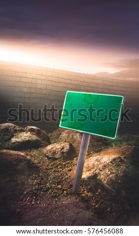border concept with blank sign in front of a high wall and dramatic lighting