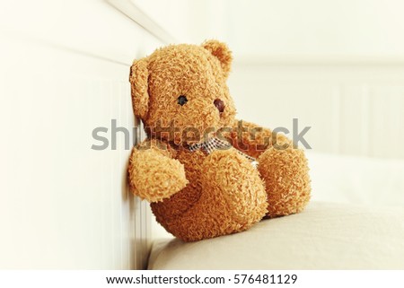 Lonely Teddy Bear sitting in the white room. Concept about waiting for someone and loneliness. (Focus on bear's eye)