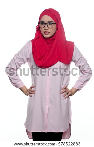 A pretty young muslim lady / woman with hijab looking angry at the camera isolated on white background