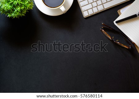 Modern dark surface office desk table with computer and cup of coffee. Hero Header Concept with Copy space. Royalty-Free Stock Photo #576580114