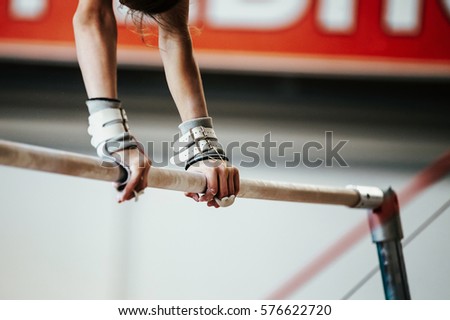 hands young girl gymnast exercise on uneven bars