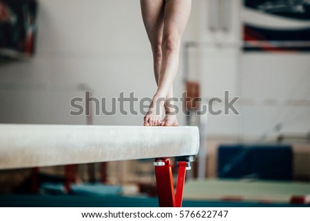 feet young girl athlete gymnast on balance beam Royalty-Free Stock Photo #576622747