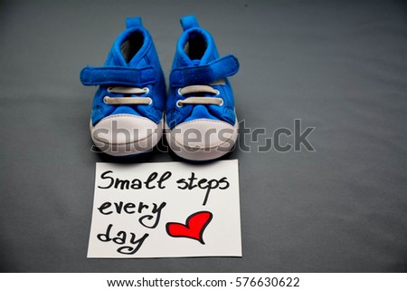 Baby's bootees and small steps every day text on a note