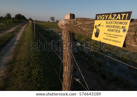 Electric fence for animals with "Danger, high voltage" sign